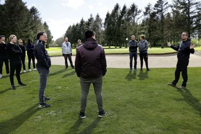 Chefgreenkeeper Claus Studsgaard Nielsen var taknemmelig for den frivillige indsats, og instruerede medlemmerne og deres nærmeste familie, inddelt i små grupper, i at bruge rive, grensaks og lappe slaghuller i på fairway. Foto: Henrik Ole Jensen