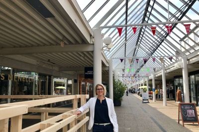 Julia Thaarup Johansen ærgrer sig over to ophørsudsalg i Strøgcentret men glæder sig til gengæld over grøde i gaden. Centrets nye spisested, Gastro Mekka, er ved at få bygget terrasseanlæg og en ny butik på er trapperne. Foto: Jette Aaes