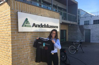 Anne Merete Kongensgaard fra Andelskassen Ikast viser den trøje, som man under corona-nedlukningen har fået lavet til det lokale special olympics håndboldhold. Det er håbet, at få sat trøjen i en større produktion, så den kan sælges til støtte for hele para-sporten i Ikast-Brande Kommune. Foto: Privatfoto