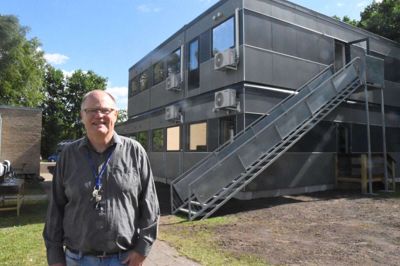 Skoleleder Svend Erik Schmidt foran den nye Guldmine. Der er formentlig tale om en midlertidig løsning, men han vil ikke sætte årstal på, hvornår de såkaldte letvægtsbygningen bliver afløst af en permanent skolebygning. Indtil videre er han lykkelig for, at udflytningen til campus-miljøet går efter planen. Foto: Flemming Thulstrup