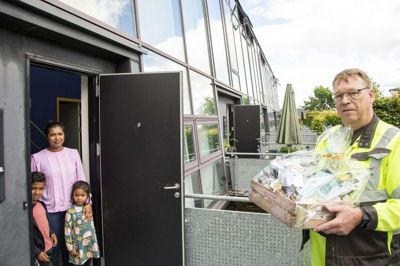 I den nuværende bolig i Frisenborgparken tager familien Suntharalingam imod en gavekurv fra Energi Ikast som energiselskabets kunde nummer 8000. Den glade giver er VVS’er Finn Knudsen fra Energi Ikast. Foto: Privatfoto