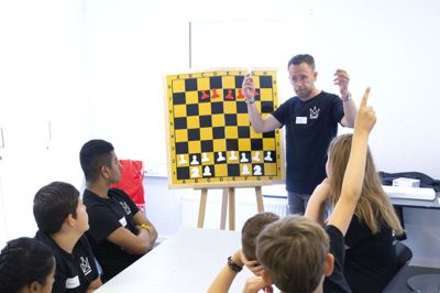 Læringschef hos Dansk Skoleskak, Mikkel Nørgaard, er her i gang med at indvi boost brainere fra Ikast i skakspillets mysterier. Foto: Tom Laursen