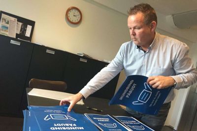 Chefen for Vores Ikast, Jan B. Knudsen er ved at have styr på den nye skiltning til Strøgcentret, hvor der fra torsdag er krav om mundbind. Foto: Laila Kempel