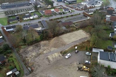 Byggeriet af 14 nye boliger er sat i gang på en grund for enden af Fuglsangs Allé i Ikast. Projektet har fået navnet Fuglehuset. Øverst i billedet ses erhvervsområdet ved Nygade, og til højre i billedet ses Østergade, der ved krydset skifter navn til Bordingvej. Foto: Flemming Hansen
