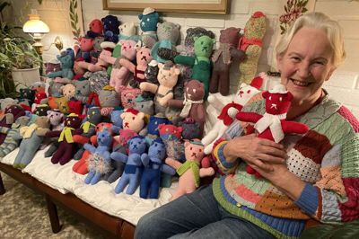 Tinne Kristensen med bamse nummer 100 og i baggrunden en god portion af andre bamser på vej ud til børn gennem Røde Kors. Foto: Privat