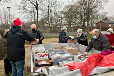 Formanden for Ældre Sagen i Ikast, Hans Peder Nielsen (med nissehuen), uddeler platter til deltagerne i Ældre Sagens årlige julefrokost - i år sammen hver for sig. Foto: Jette Aaes