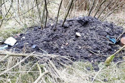 En kæmpe bunke affaldsjord er blevet læsset af på Ruskjærholm, Jord, spraydåser andet ikke nedbrydeligt affald er dumpet i området. Foto: Privat