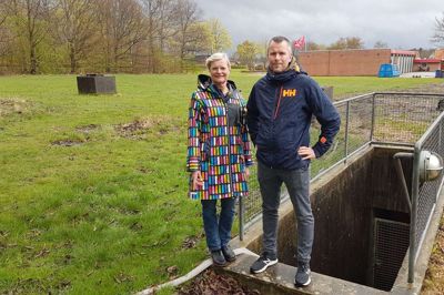 Koldkrigsbunkeren på Ellehammervej i Ikast har fået ny ejer. Køberen er Ikast Fysioterapi & Træning, og målet med erhvervelsen af den 5002 kvadratmeter byggegrund på hjørnet af Thomas Poulsens Allé og Marienlunds Allé er at opføre et sundhedshus på 1600 kvadratmeter. Årsagen til byggeplanerne er, at de nuværende rammer på Danmarksgade er for trange til at opfylde hverdagens behov og fremtidens udvidelse af firmaet. Her ses medejerne Kathrine Philipsen (t.v.) og Jens Ole Staunstrup ved nedgangen til den tidligere kommandocentral. Firmaets tredje medejer Karen Nissen kunne ikke være med, da billedet blev taget. Foto: Thomas Vang Nielsen