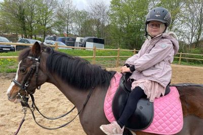 Hestene gik på skift og havde mange små glade piger og drenge på ryggen til en trækketur. Her er det femårige Sofia, der får en trækketur på en elevhest.