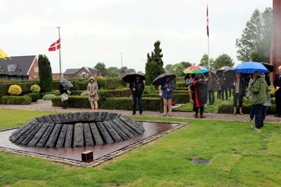 Himmelsluserne var åbne, og det krævede vandspejl på plads, da Isenvad søndag formiddag indviede en ny Jens Christian Jensen-skulptur på kirkegården. Foto: Laila Kempel