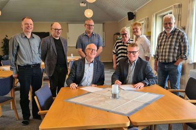 Mission Afrika og KFUM’s Soldatermissions forretningsudvalg er samlet med generalsekretærerne ved pennen for at underskrive delingsaftalen. Foto: PrivatFoto