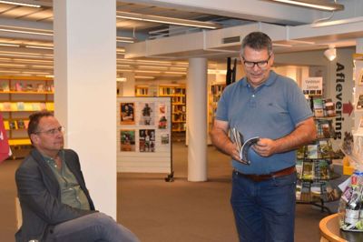 Kultur- og biblioteksleder Martin Lundsgaard-Leth sidder og lytter, mens kulturkonsulent Carsten Jensen læser op af Per Højholts digt om Ikast, der vækker til almindelig eftertanke. Foto: Flemming Thulstrup
