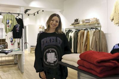 Indehaver Elena Taskirani døren til sin nye butik, hvor kunderne både kan gå på opdagelse i modeuniverset og få klippet lokkerne. Foto: Privatfoto