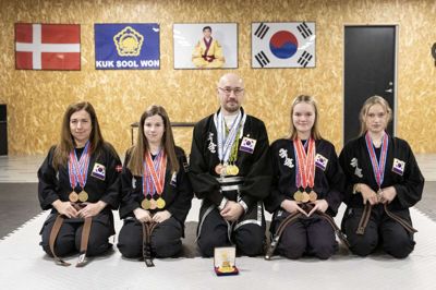 Ikast er hjemsted for Danmarks første og foreløbig eneste klub med den sydkoreanske kampsport Kuk Sool Won. Klubben blev stiftet i 2018 af engelske Phil Brooks - et halvt år efter han flyttede til Midtjylland. Her ses fem af de syv medlemmer, som i november var til de europæiske mesterskaber i Kuk Sool Won og kom hjem med et læsfuld medaljer. Fra venstre ses 46-årige Matilda Lory, 12-årige Melissa Lory, 51-årige Phil Brooks, 13-årige Sofia Kjærgaard Pedersen og 14-årige Mathilde Rodam. Foto: Tom Laursen