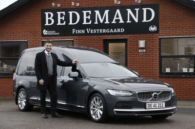 En stolt bedemand foran sin nye hybrid rustvogn. Finn Vestergaard har netop fået sin nye bil og kan fremadrettet køre helt lydløst med afdøde. Foto: Henrik Ole Jensen