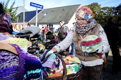 77-årige Jytte Larsen har været med til Duedag i Ejstrupholm i mere end 25 år. Hun sælger blandt andet farvestrålende huer, som hun selv hækler. Foto: Chresten Bergh