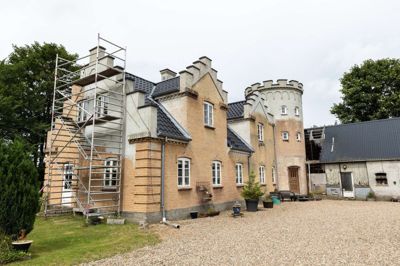 En hel unik familievilla i Gludsted med gesimser, tårn og skydeskår på toppen er over de sidste 14-15 år vokset frem i landsbyen Gludsted. Murer Jes Nørgaard Jensen udfordrer sin egen faglighed og går stik imod nutidens byggemode.