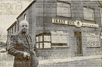 Bogtrykker, bladudgiver og redaktør Preben Jensen foran den avis- og trykkeribygning med facade mod Strøget, som havde huset virksomhederne siden 1932. Oprindeligt lå virksomheden på adressen Strøget 59 (tidligere Bredgade), hvor et renseri siden rykkede ind. Foto: Arkiv
