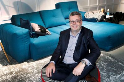 Flemming Hansen. BoConcepts kommende administrerende direktør, Torben Paulin, er straks med på ideen, da fotografen foreslår, at han på billedet skal sidde i skrædderstilling på et tæppe.