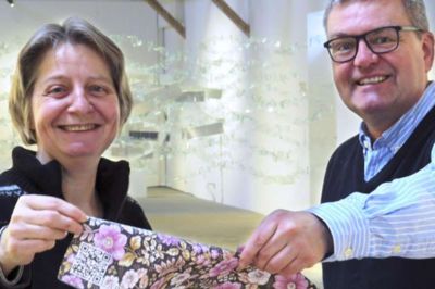 Kim Kristensen. Bente Jensen og Steen Aaes-Jørgensen fra Kunstpakhuset viser her et eksempel på en QR-kode (den hvide firkant i venstre hjørne af plakaten). De vil gerne hjælpe til, så den kommunale kunst kan blive formidlet via disse koder. Privatfoto