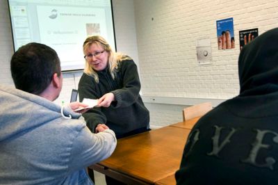 Chris får overrakt sit kursusbevis af Tone Strømberg i lokalet, hvor kurserne foregår. ?Foto: Tom Laursen