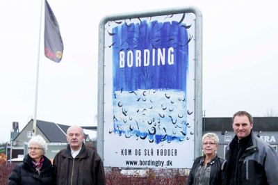 Bording Erhvervsforening står bag opsættelsen af skilte med byens nye slogan, som blev skabt i forbindelse med projekt »Kunsten i Bevægelse«. I venstre side ses Tonny Høegh Poulsen, formand for erhvervsforeningen i selskab med Anna Munk Nielsen, som stod i spidsen for det lokale engagement ved »Kunsten i Bevægelse«. I højre side af billedet er de to medlemmer af erhvervsforeningen Anita Marquart og Michael Falkenberg. ?Foto: Tom Laursen