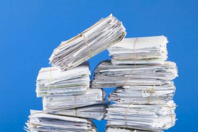 Pile of envelopes, letters, bills, forms. Isolated on blue