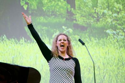 Musicalperformer Mona Britt Nørkjær, der til daglig arbejder som kordegn ved Bryrup, Vrads og Vinding kirker, skiftede kjole tre gange undervejs i koncerten. Her rammer hun det høje C i en morsom sang om altens genvordigheder. ?Foto: Henrik Ole Jensen