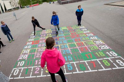 Skolepolitik er ikke en simpel øvelse i at flytte penge rundt, mener skribenterne her. Billedet er fra skolegården ved Kibæk Skole, hvor en stor taltavle giver eleverne mulighed for at motionerer både hjerne og fysik.