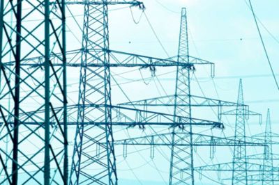 Many power poles of a power line. Pylons in front of the open sky