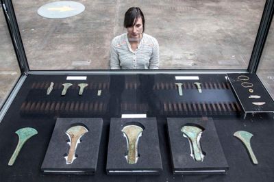 Her ses hele det spektakulære bronzealderfund i en sikkerhedsmontre på Museum Midtjylland. Ud over de fem store økser, er der nogle mindre økser, som måske har været brugt til at hugge processionsvejens stolper til med, fortæller arkæolog ved Museum Midtjylland Constanze Rassmann. Bagefter er de små økser blevet varmet op, og så har man hamret på dem, så de gik i stykker, for man skulle ikke bruge dem længere, og man kunne ikke smelte dem om. Det var tabu, fordi stedet blev betragtet som helligt. ?Foto: Tom Laursen