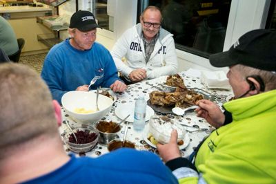 Her i cafeteriet på Sunds Sø Camping spiser håndværkerne aftensmad hver aften ved 17-17.30-tiden. Kort efter går de til ro i hver deres campingvogn. Det er Anders Jensen i blå trøje og Jan Jørgensen i hvid, mens Finn Hansen sidder med ryggen til i den gulgrønne jakke.? Foto: Tom Laursen