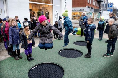 0. og 2. klasse fra Parkskolen var de første til at prøve de nye trampoliner i Søndergade, og de var et hit hos børnene. Det grønne sikkerhedsunderlag er i øvrigt lavet af gamle gummisko. ?Foto: Henrik Ole Jensen