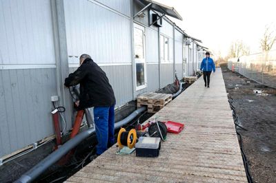 Håndværkerne er stadig i gang med at få alle installationer på plads i de 10 pavilloner, der hver har fire værelser og et toilet med håndvask. Bagerst er daglig leder Vibeke Møller rundt for at hilse på nogle af de nye beboere. ?Foto: Tom laursen