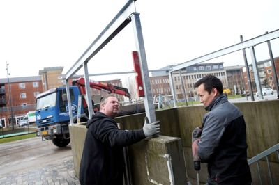 Smed Brian Sørup og voksenlærling Kristian Hansen fra Hammerum Stålbyg monterede i går det stålskelet, som Udviklings- og Entreprenørfirmaet KPC har bestilt for at holde de tre trappeskakter på Kousgaards Plads fri for sne og regn. ?foto: Flemming Hansen