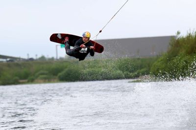 Den nye kabelbane gør det meget lettere for børn og unge at stå på wakeboard. De bliver trukket frem og tilbage over vandet og kan undervejs flyve hen over ramperne, når evnerne er til det. Robin Nielsen fra Herning Vandski & Wakeboard Klub var første mand på vandet efter den officielle indvielse lørdag.? foto: flemming hansen