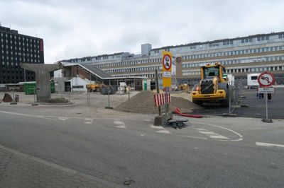Renoveringsarbejdet er godt i gang på banegårdspladsen - her set fra biografsiden. Til venstre er gangbroen pillet ned, og i midten ses den afspærring, der lukker Sølvgade for andet end busser. Det er den, som mange bilister til buschaufførernes ærgrelse ignorerer. Til højre anes den nyasfalterede plads, som også kun er for busser. ?Foto: Kenneth Meinby Sørensen
