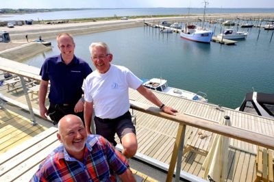 Thomas Møller Jensen (t.v.), Johannes Ruby (t.h.) og Christen Dam Larsen ser frem til en sommer fyldt med aktiviteter i Handbjerg Marina. Blandt andet holdes der koncerter på musikkutteren L350, som ses i baggrunden af billedet. Den kan du læse mere om på næste side. Foto: Sune Nordby