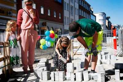Milla Sørvad får hjælp af brolægger Lars Kortrum med at lægge den store tunge brik til det enorme puslespil, som det er at lægge ny belægning på Hernings gågade. ? foto: flemming hansen
