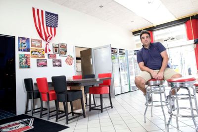 Timur Taskin serverer fastfood i butikslokalet ved Uno-X-tanken i Poulsgade, hvor der også er en særskilt spilleafdeling. ? foto: tom laursen
