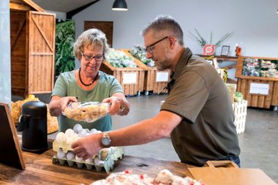 Axel Månsson har åbnet gårdbutik med økologiske varer. Her er det Elin Lægdsgaard, der køber nogle friske æg. ?Foto: Tom Laursen
