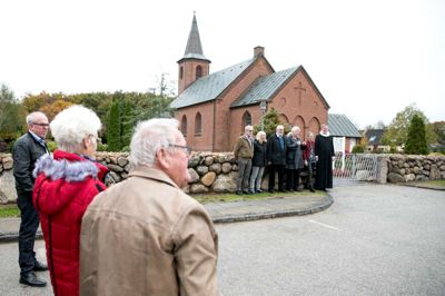 Kølkærs menighedsråd og sognepræst Poul Nygard Kristensen poserer til ære for fotograferne ved det nye kirkegårdsdige. Ikke alene er stendiget flot i sig selv, men de træer, man har været nødt til at fjerne i forbindelse med etableringen af diget, har givet et helt anderledes, flot udsyn til kirken. ?Foto: Tom Laursen