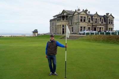 Jarl Tranekær Jørgensen på 18. green på Old Course i St. Andrews med Royal and Ancient Clubhouse i baggrunden. Den 30-årige greenkeeper-elev tilbragte fire uger på verdens ældste golfbane og samlede inspiration til arbejdet i Herning Golf Klub. ?Foto: Privatfoto