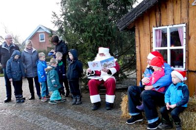 Julemanden hygger sig med de fremmødte børn. ?foto: Ester Foto