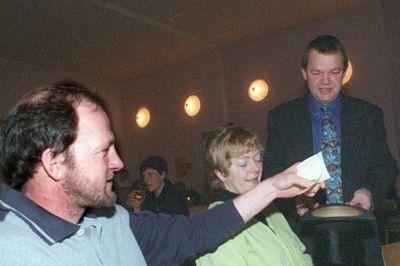 Den socialdemokratiske partiforening i Engesvang har haft politiske caféer i mange år. Her er det en situation fra 1999, hvor en ung og slipseklædt konferencier Frank Heidemann, samler spørgsmål fra salen i en hat. Manden, der ønsker svar på noget er Jens Erik Lorentsen.? Foto: Herning Folkeblad