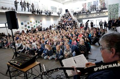 Eleverne på Vildbjerg Skole var samlet på torvet for at deltage i grandprix-fejringen. Skolens musiklærer, Jerry Vergara, har været med til at stable arrangementet på benene gennem Skolernes Musikudvalg, og han var glad for resultatet. - Jeg synes, det gik forbavsende godt. Det er jo ikke korsang, det er fællessang, og hver fugl synger med sit eget næb, men jeg synes, at det samlede lydbillede var godt, sagde han efterfølgende. ? Foto: Henrik Ole Jensen