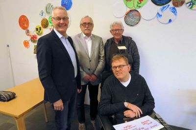 Lions Club »Uldjyderne« har givet 10.000 kroner til Hjerneskadeforeningens arbejde for hjerneskadede og deres pårørende. Fra venstre er det Jørgen Kielstrup, Lions Club, Elmer Gade, Hjerneskadeforeningen Midt/Vest og Leo Lykke Larsen, der er far til Søren Lykke Larsen i kørestolen.? foto: jesper wind