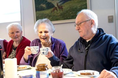 Inga Tønnesen (midten) og John Hjuler skåler i kaffe. De stærke sager bliver kun serveret til festerne, men snakketøjet er med til hvert eneste møde.