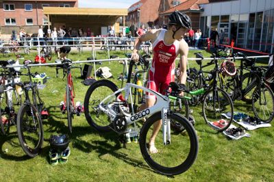 Her er det triatleten Matthias Lyngsø Petersen fra værtsklubben, der henter sin cykel. Han er på landsholdet og er klædeligt iført den rød-hvide landsholdstrøje.? Foto: Tom Laursen