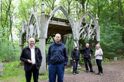 Det fem meter høje gotiske skur er lavet af René Schmidt. Han ses forrest til højre i billedet. Ved siden af ham er Søren Taaning. Bagved er Kristina Taaning, der er daglig leder af Skovsnogen, og ved siden af hende står Aksel Kror og Jørn Morsing. De er arbejdsmænd og projektudviklere hos Skovsnogen. ??foto: Tom Laursen